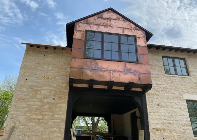Copper metal panel facade on a stone building for Roof Repair in Sappington